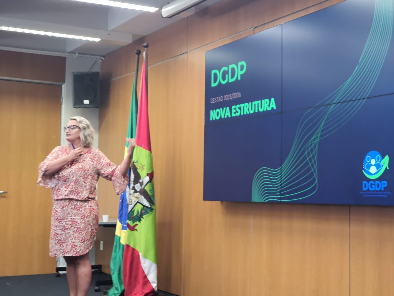 Diretora Tânia Hammes gesticula apresentando as mudanças em slide no auditório da SEA